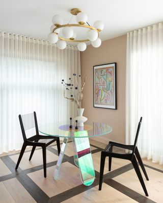 a colorful glass dining table with two seats