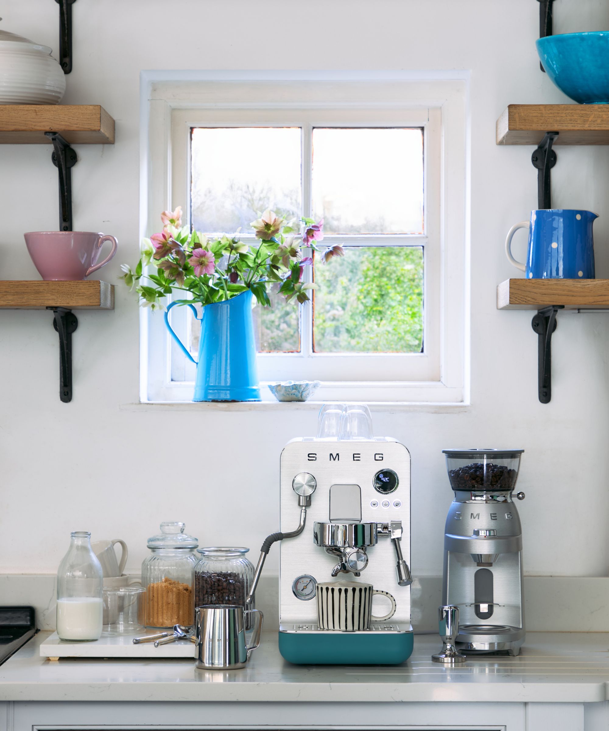 A blue and silver coffee maker on a kitchen counter