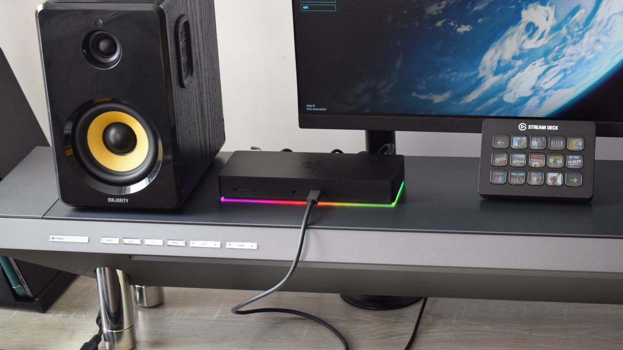 Wide shot of the Razer Thunderbolt 4 Dock Chroma on a Hexcal Studio workstation, powering computer speakers, a Stream Deck Mk 2. and a 4K monitor