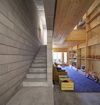 The interplay between the superimposed wood and the exposed concrete structure create a playful contrast