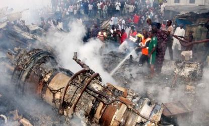 Firefighters try to put out the fire at the site of a plane crash near the Lagos airport in Nigeria on June 3. The passenger plane carrying 153 people crashed into a building on Sunday, killi