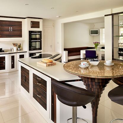 Take a tour around a modern kitchen with curved dark wood cabinets ...