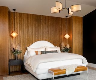 Art Deco bedroom with a curved headboard uphokstered in white fabric and wooden slatted wall paneling