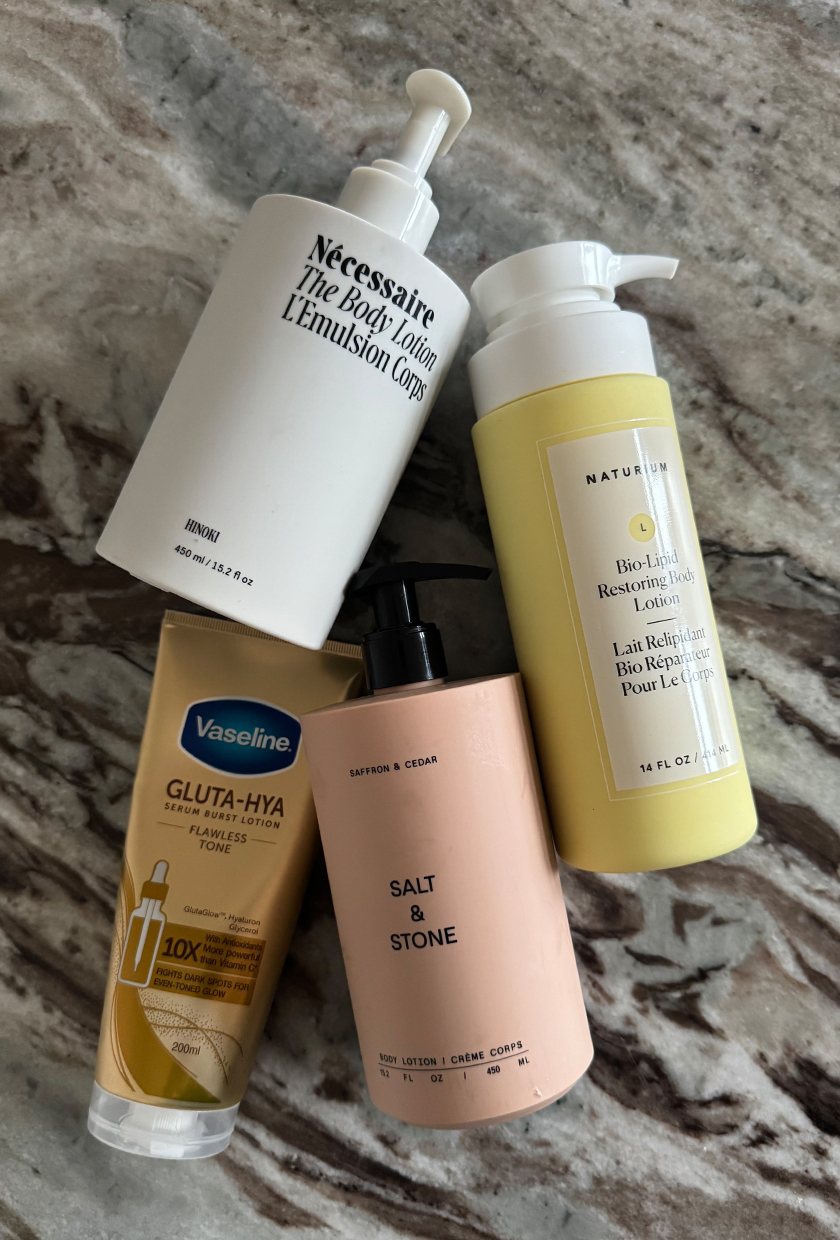 A range of body lotions on a table with marbled texture