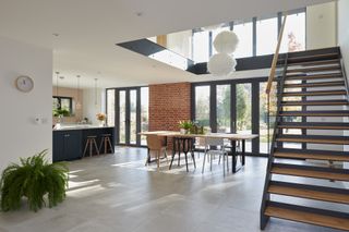 modern open plan interior with kitchen, bifold doors and steel staircase
