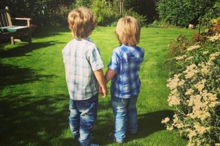 Young children holding hands looking at a garden
