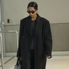 Laura Harrier wears a black outfit to the airport.