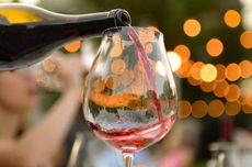 Pouring a glass of red wine from a bottle