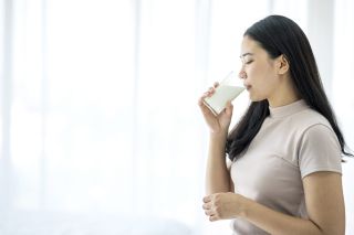 a woman drinking oat milk at home