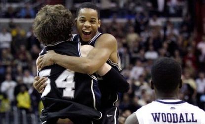 Butler Bulldog Zach Hahn (center) jumps into the arms of teammate Matt Howard (54), who made the game-winning free throw Saturday to oust the No. 1 seed Pittsburgh Panthers.