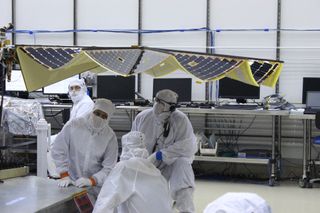 As InSight's solar arrays unfurl, test engineers carefully inspect their deployment.