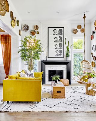 white living room with rattan bowls on the walls and a yellow sofa