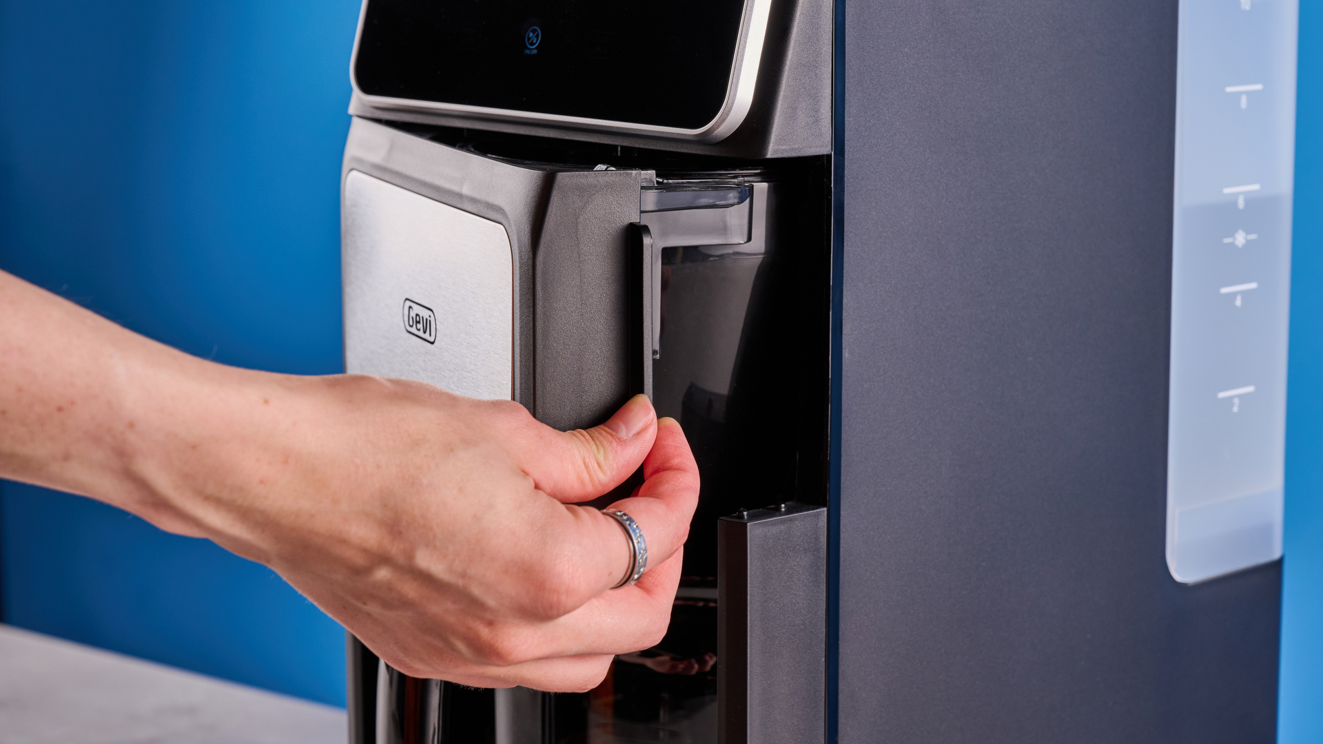 the gevi 10-cup drip coffee maker with grinder photographed against a blue background, showing the glass carafe, water tank, touch screen, and accessories including plastic filter