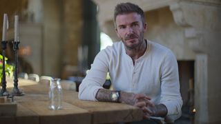 David Beckham sits stony faced at a table in his Netflix docuseries