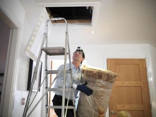 A Middle Aged Man in a suit installing insulation