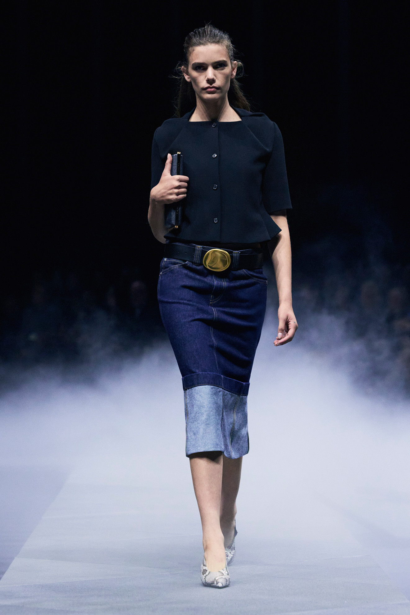 A model at the Khaite spring/summer 2026 show wearing a black top and denim pencil skirt.