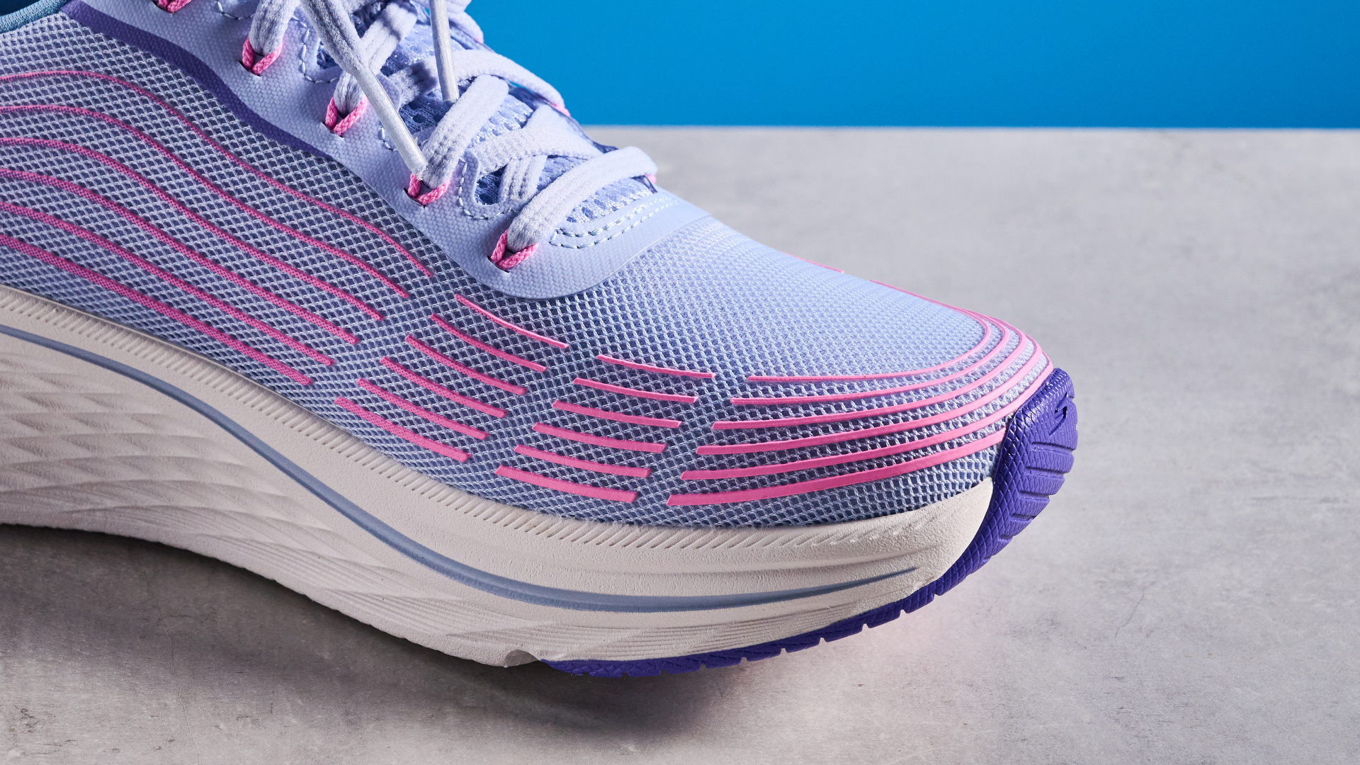 Skechers Max Cushioning Elite 2.0 running shoes photographed in front of a blue background.