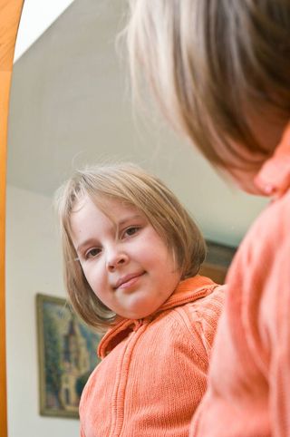young girl looking in mirror