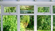Double pane windows in a conservatory with a backyard view