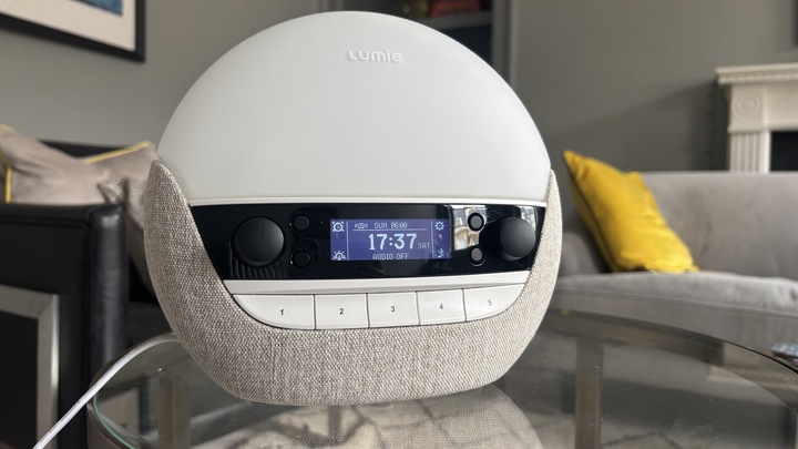 The Lumie Bodyclock Luxe 700FM sunrise alarm clock displaying the time and home screen.
