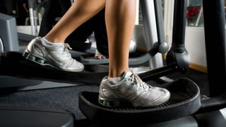 Close-up of a woman's feet in the pedals as she learns how to use an elliptical machine