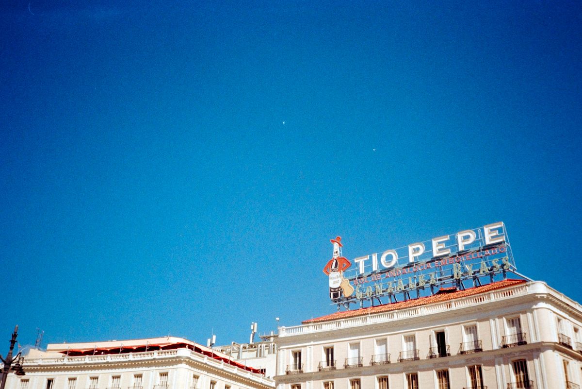Scanned and digitized film image, using Valoi Easy 35 Pro V2 and Negative Lab Pro Lightroom plugin. Image shows a 3D building sign reading 'Tio Pepe' next to a mascot against a clear blue sky