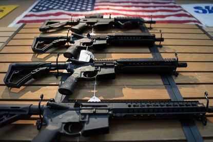 Guns line the wall under an American flag