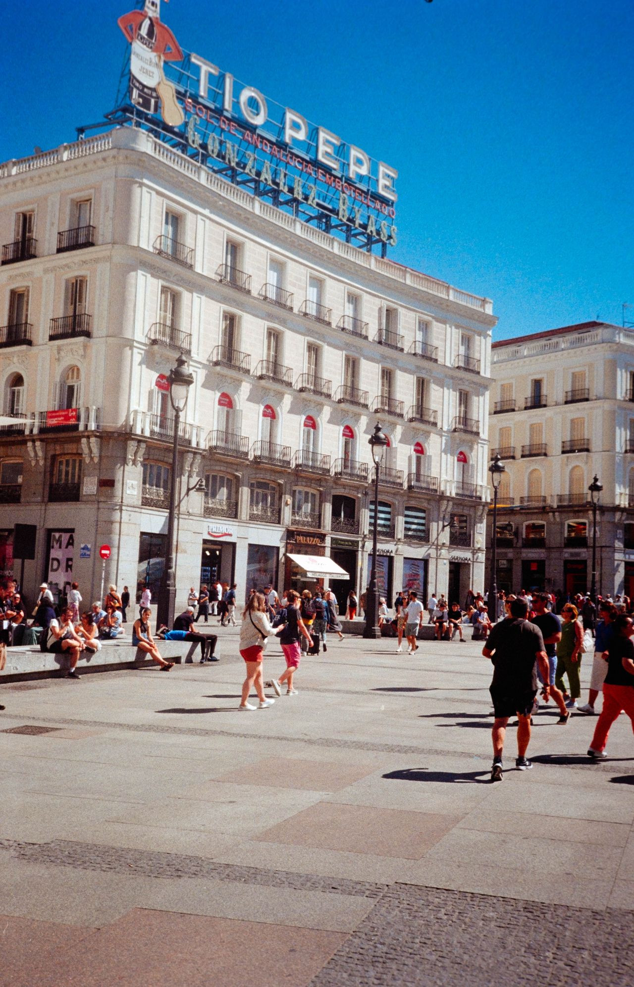 Scanned and digitized film image, using Valoi Easy 35 Pro V2 and Negative Lab Pro Lightroom plugin. Image shows a 'Tio Pepe' sign on top of a tall building above a busy, touristy street