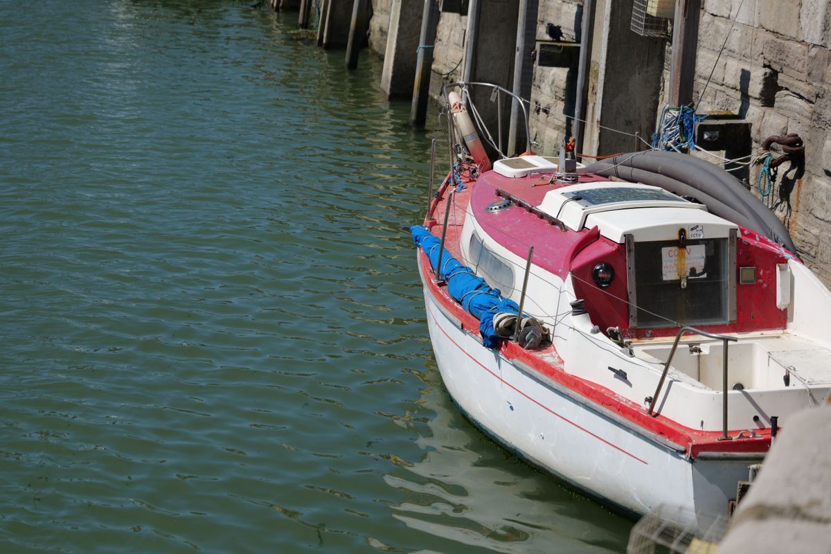 A boat moored in a harbour next to harbour wall