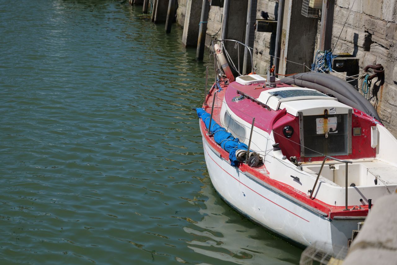 A boat moored in a harbour next to harbour wall