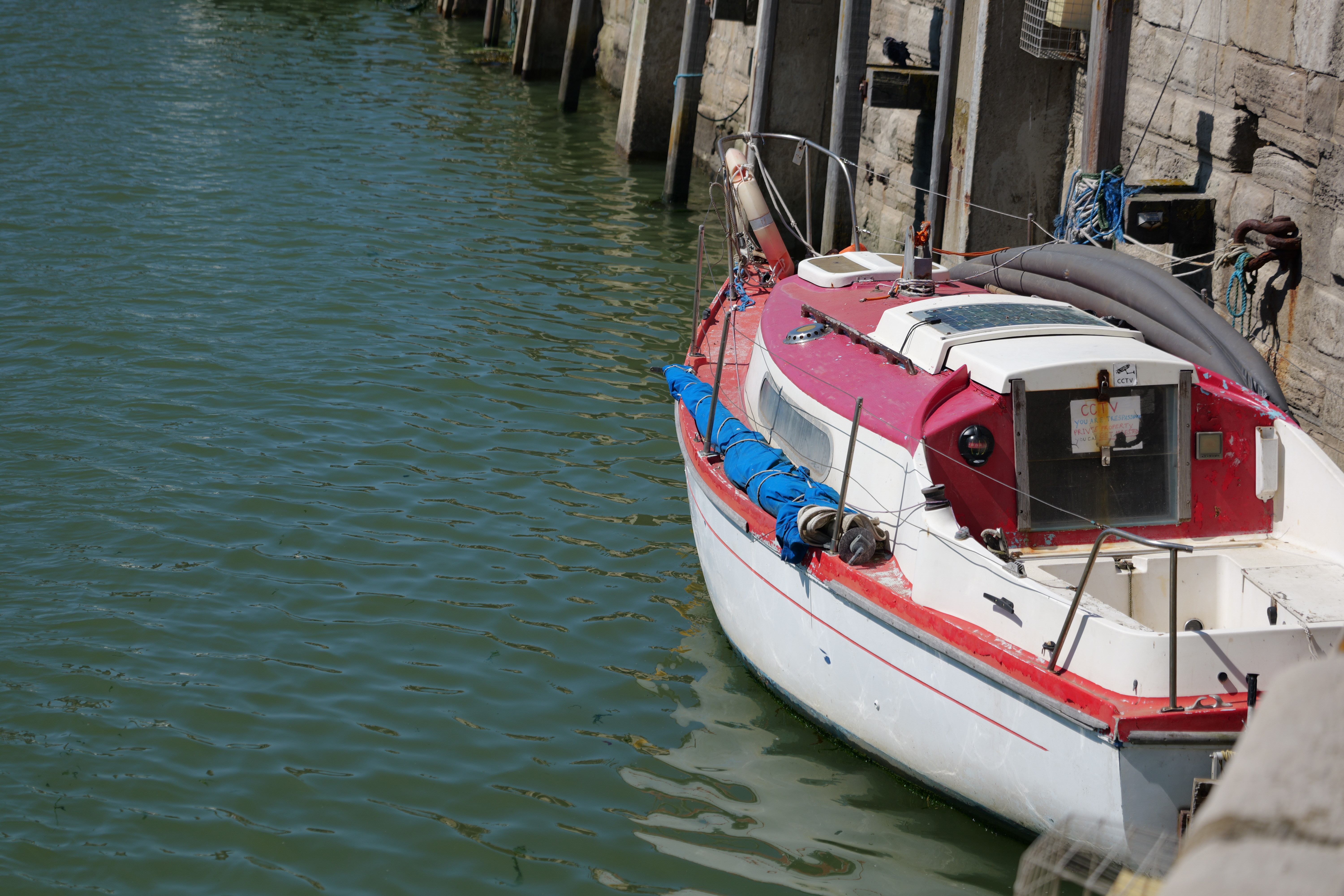 A boat moored in a harbour next to harbour wall