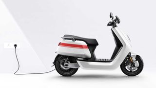 NQi GTS electric scooter in white charging via cable