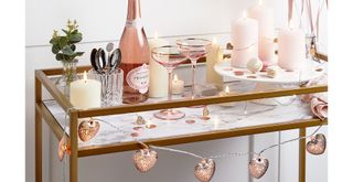 Valentine's day decoration bar cart with heart-shaped lights and pink accesssories