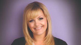 Tanya Branning smiling at the camera with a purple background.