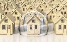 Home insurance concept: Toy wooden miniature houses, one under glass dome.