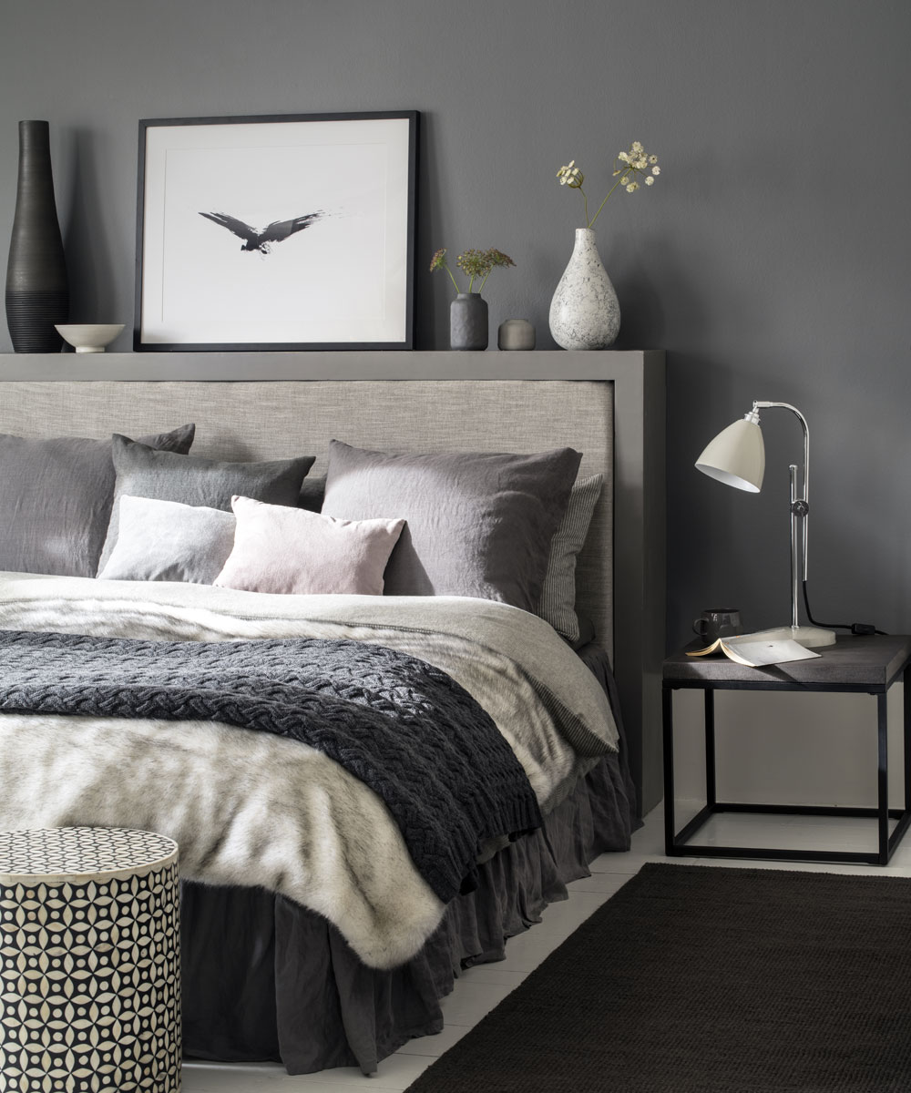 grey bedroom with bed and white lamp