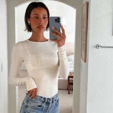 @tylynnnguyen wearing a white long-sleeve T-shirt and jeans
