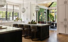kitchen with off-white cabinets, oak island and marble countertops