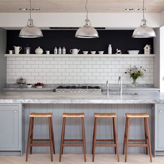 grey kitchen with white subway tiles and island with marble