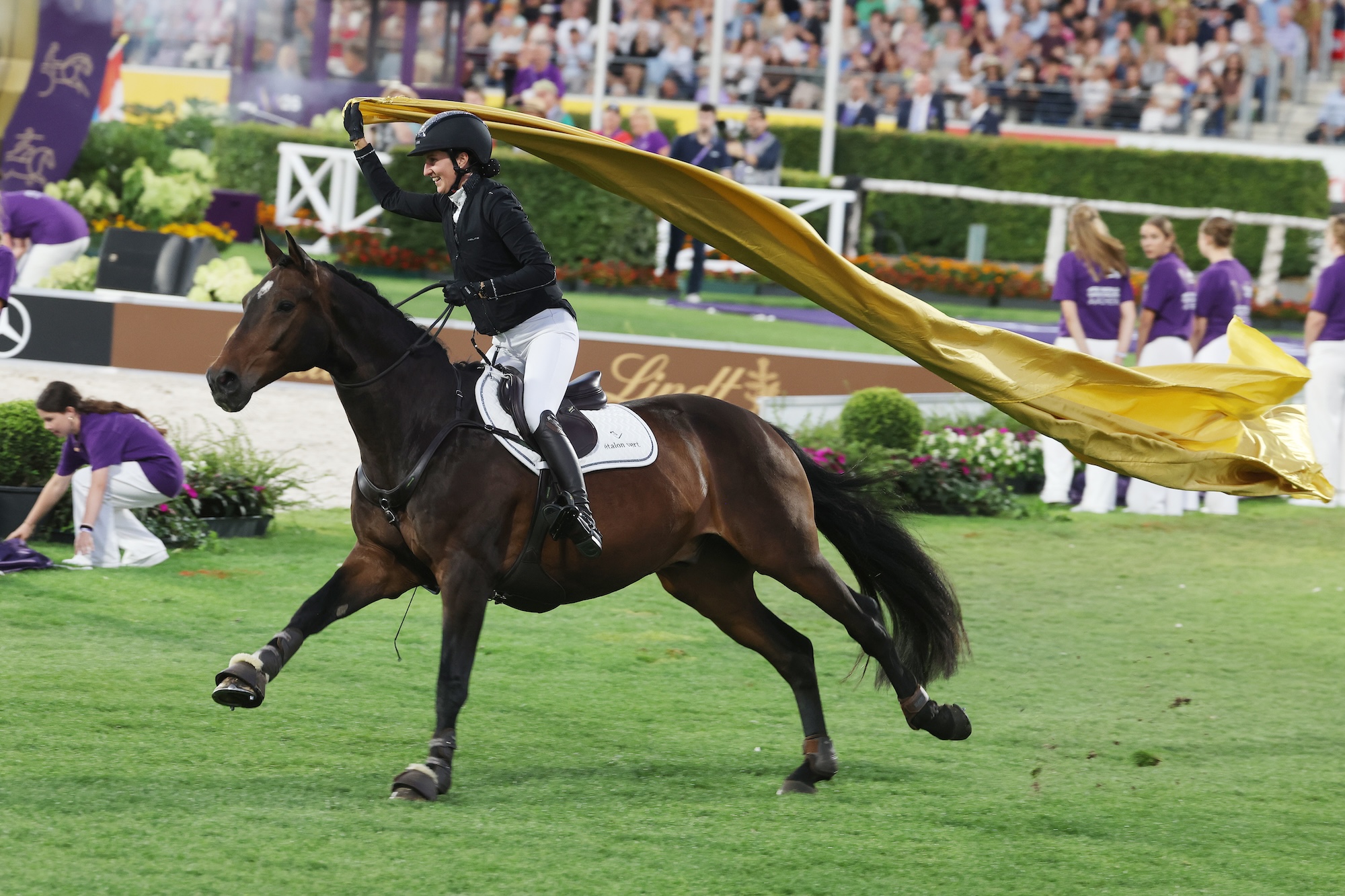 Lisa R&ouml;ckener and her horse gallop bridleless round the Aachen arena with a golden flag