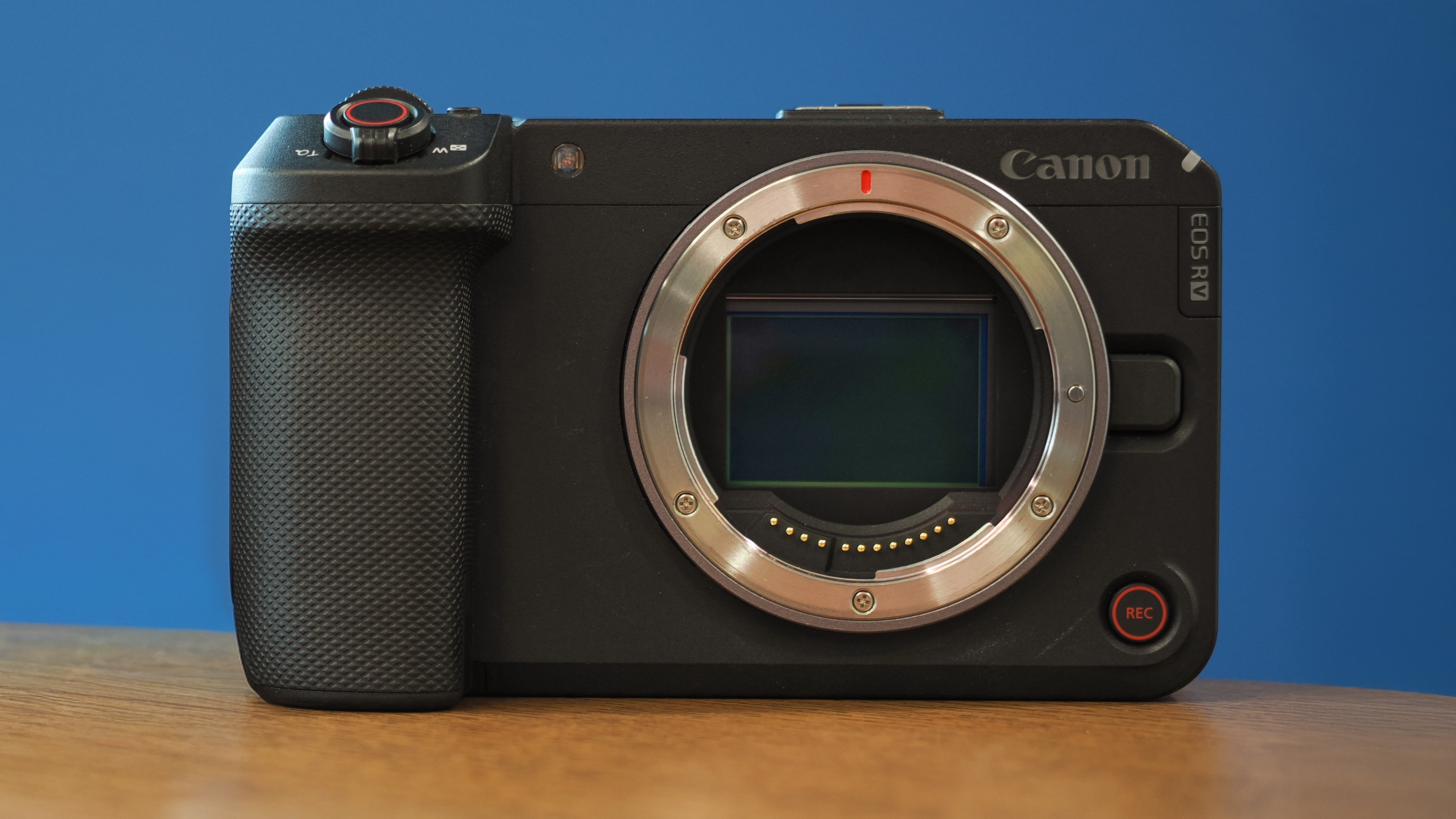 Canon EOS R6 V on a wooden surface against a blue background