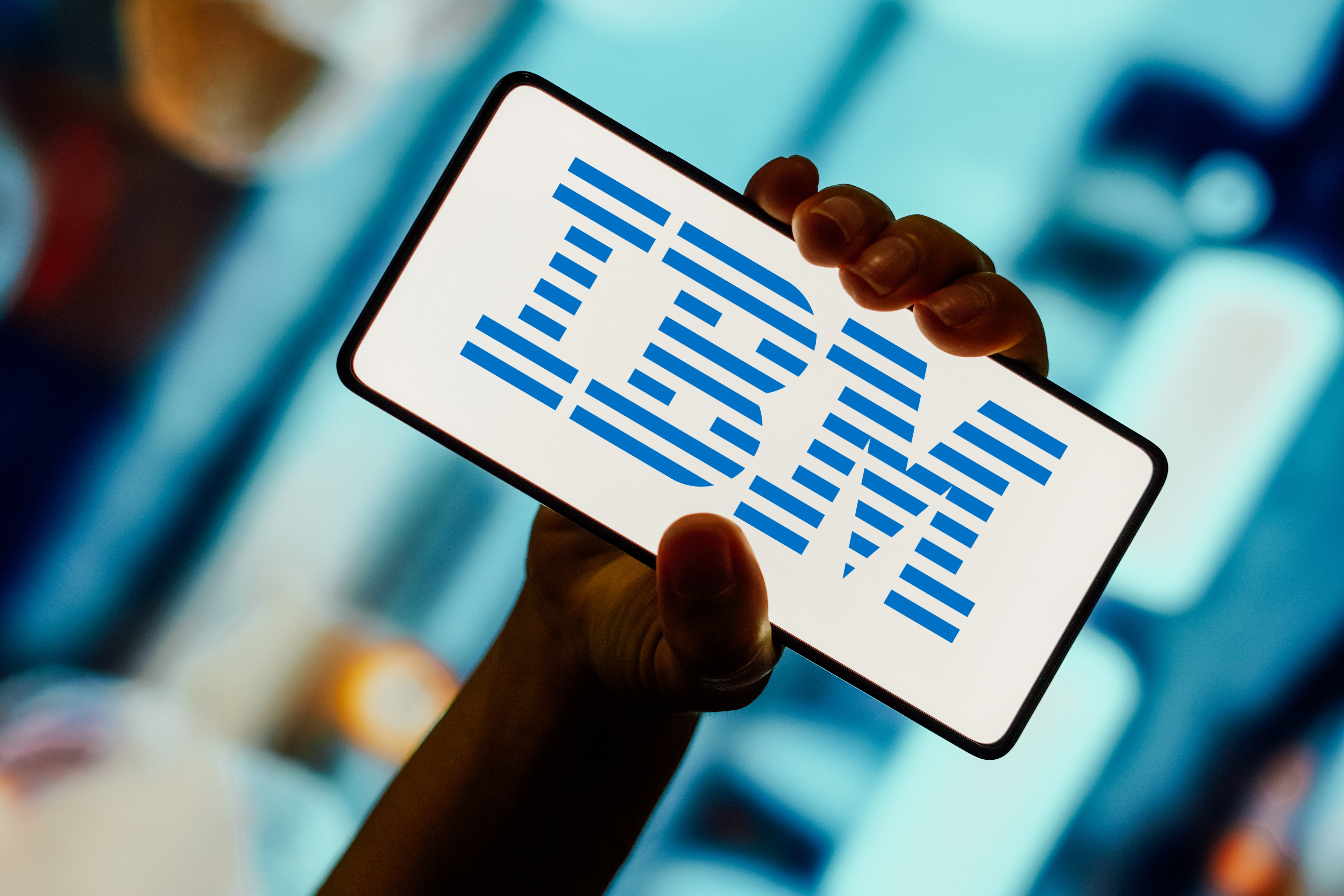 IBM logo displayed on a smartphone screen with blurry image in background