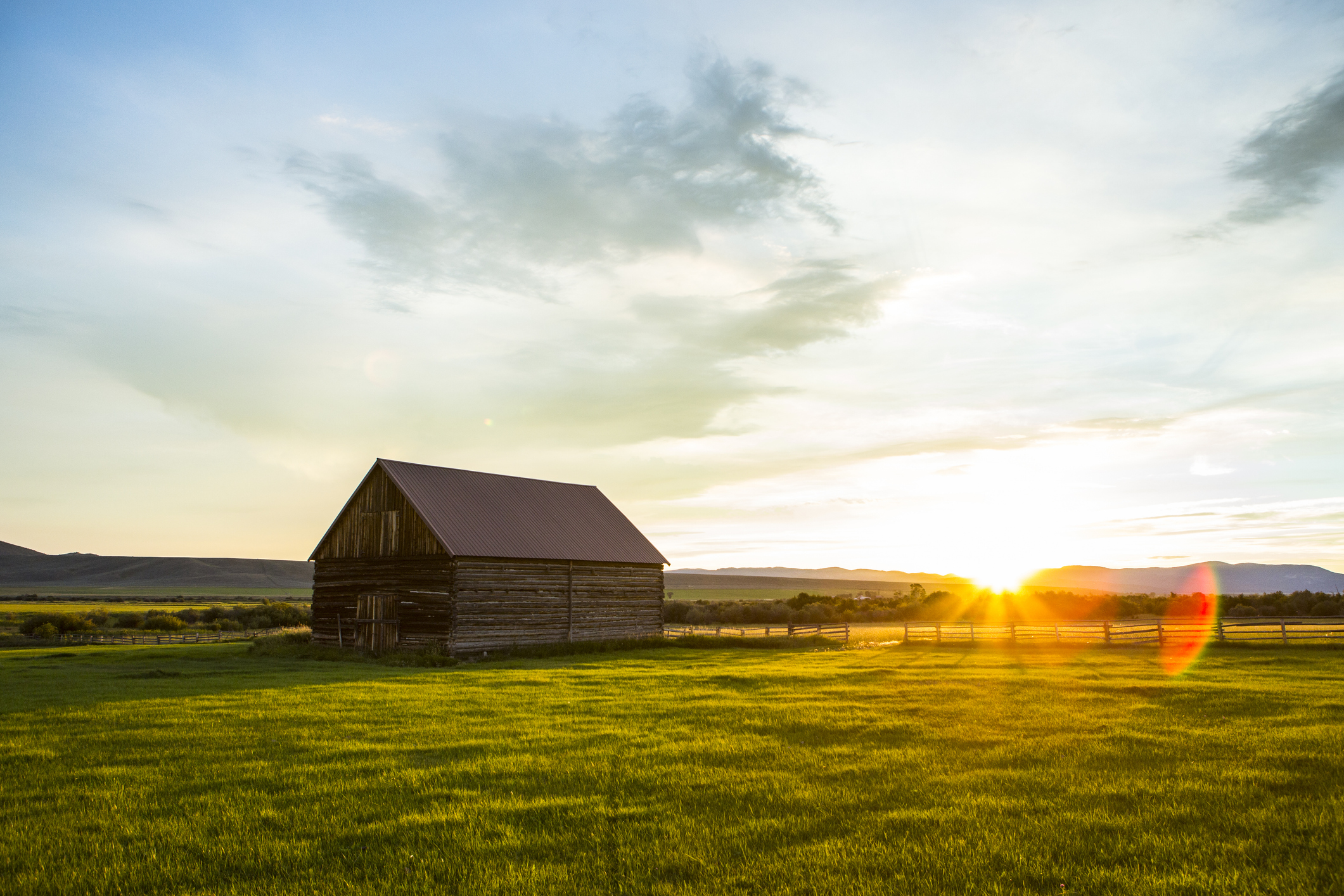 An old Montana wood barn in a field at sunrise