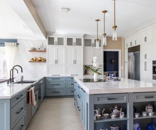 Kitchen design with light blue lower cabinets and kitchen island paired with white upper cabinets