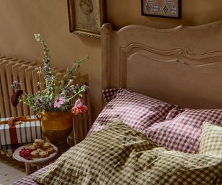 Red and green bedding on a bed against brown walls.