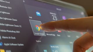 finger pointing at google chrome icon on screen