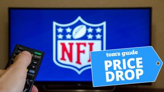 A TV displaying the NFL logo with a remote control pointing toward it
