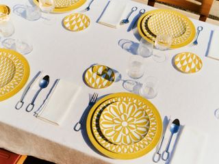 ‘Soleil d’Hermès’ yellow and white patterned tableware on a laid table