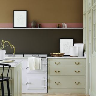 Kitchen with pale green units and olive and dark green walls