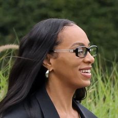 Solange wearing a black coat, baggy jeans, heels, and a Loewe puzzle bag